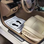 driver's seat of car after being detailed with protective paper on the floor